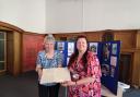 Nancy Gibson, of Dunfermline Cricket Club, hands over some of the archive material to Sharron McColl at  Dunfermline Carnegie Library and Galleries.