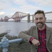 Tim Dunn, presenter of the Yesterday TV programme, The Architecture The Railways Built, at the Forth Bridge. Photo: UKTV/Brown Bob Productions