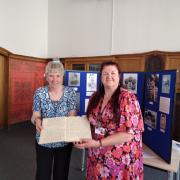 Nancy Gibson, of Dunfermline Cricket Club, hands over some of the archive material to Sharron McColl at  Dunfermline Carnegie Library and Galleries.