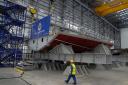 A worker passing the keel before the keel laying ceremony for the first type 31 frigate at Rosyth.