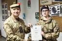 Captain Mark Elliot presents Cadet Lance Corporal Rubyann Held with her certificate and badge on completion of her Duke of Edinburgh silver award.