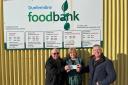 Lodge Canmore members Jeff Crichton (left) and David McColl present their cheque to Sandra Beveridge, the foodbank's project manager.
