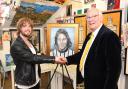Jim Leishman with self-taught artist Craig Reid as the Dunfermline Athletic legend is presented with a portrait of his younger self from 1972. Photo: David Wardle