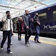 Scotrail passengers by a train. Credit: PA