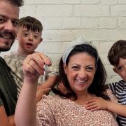 Olga, Spiros, and sons Aggelos and Achilleas on the day they received the keys to their shop in East Port.