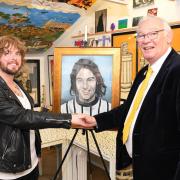 Jim Leishman with self-taught artist Craig Reid as the Dunfermline Athletic legend is presented with a portrait of his younger self from 1972. Photo: David Wardle